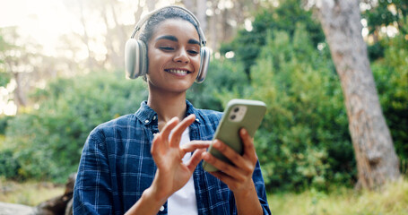 Woman, music and headphones with phone in forest for hiking podcast, audio playlist and track for...