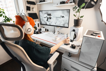 Side angle of gaming desk featuring VR headset, high-quality speakers, and modern accessories. Gamer actively plays while interacting with customizable gaming controls for a competitive edge.