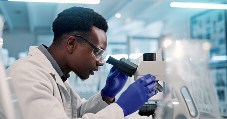 Microscope, black man and scientist in laboratory for medical research, discovery or project on...