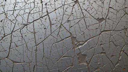 Scratched and scored metal surface, exhibiting a network of fine, interlacing abrasions alongside deeper gouges and impacts