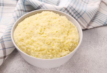 Vegetarian breakfast: millet porridge in a white plate on a gray background