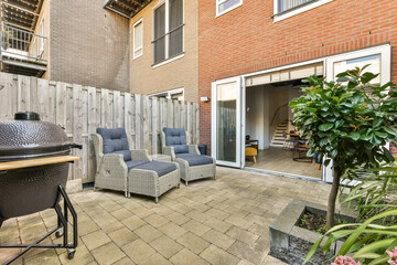 Fototapeta premium A serene outdoor patio featuring comfortable seating, a BBQ grill, and a nice plant. It's perfect for relaxation and gatherings in a modern urban setting.