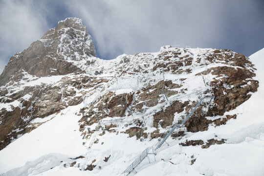 Cliff with staircase and rockfall nets on the Sphinx at Jungfraujoch