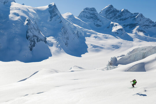 Backcountry skier jumps into the air on Aletsch Glacier