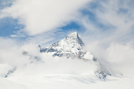 Jagged mountain peak with valley glacier and swirling clouds