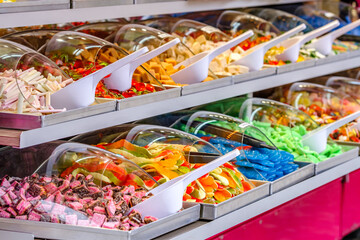 Colorful candy display at a market featuring various sweets and treats during a sunny day