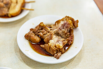 Taiwanese braised pork trotter, showcasing tender meat and rich soy sauce flavors, served on a simple white plate