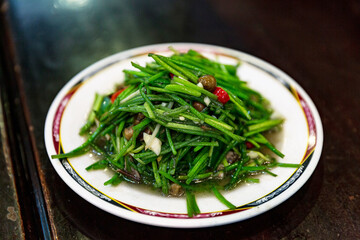 Traditional Hakka stir-fried aquatic vegetable, crunchy water lily stems with garlic, showcasing fresh and savory Hakka flavors
