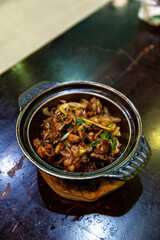 Kung Pao Frog, sizzling clay pot dish, featuring succulent frog legs stir-fried with crunchy peanuts, dried chilies, and aromatic herbs.