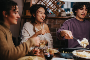 A group of friends gather around a dinner table, sharing food, stories, and enjoying each other's company. The warm atmosphere creates a sense of togetherness and community during this joyous meal.