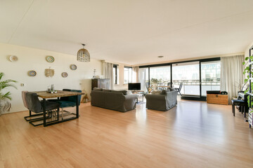 A stylish office interior showcasing a blend of modern furnishings and abundant natural light, ideal for collaborative work. The space features a minimalist design.