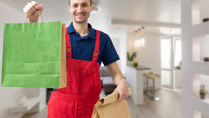 Young handsome man holding delivery paper bag