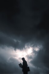 Fototapeta premium Person stands against a dramatic sky with clouds holding an object.