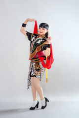 A young female dancer in traditional Jathilan costume poses gracefully, wearing detailed embroidery, red scarf, and batik elements, representing the vibrant culture of Javanese heritage.