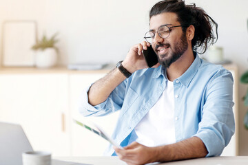 Western Man Freelance Designer Talking On Cellphone With Client, Discussing Future Project, Sitting...