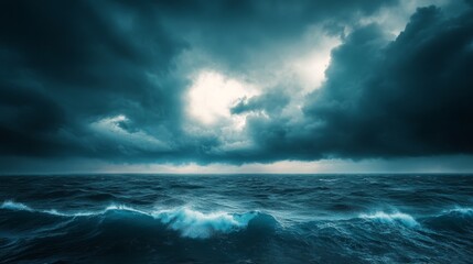 Obraz premium Dark stormy sky over the ocean, with waves and a ray of light breaking through.