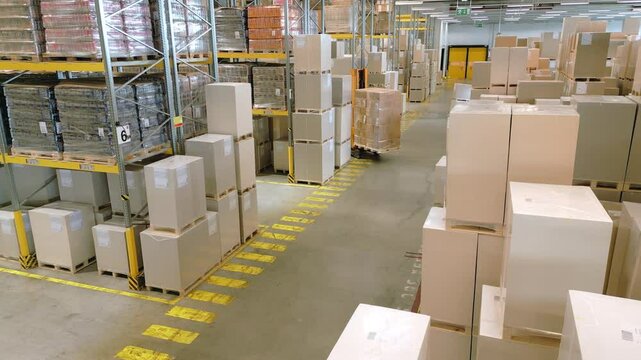 A vast warehouse reveals rows of stacked boxes and crates, highlighting efficient storage and organization. The aerial view showcases the vastness and systematic layout of the space.