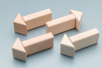 Arrow symbol made up of wooden toys, with one arrow pointing in the different direction to the others