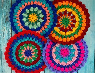 Crocheted mandala doily on wooden background handmade decor art craft photo	
