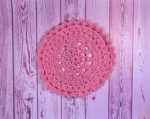 Crocheted mandala doily on wooden background handmade decor art craft photo	
