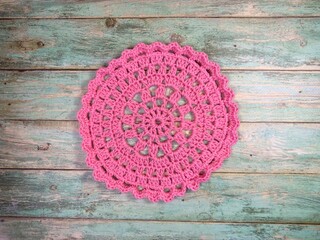 Crocheted mandala doily on wooden background handmade decor art craft photo	
