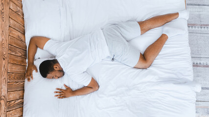 Fast Asleep African Man Sleeping Lying On Stomach Resting Peacefully In His Comfortable Bed In...