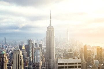 Sunset view of Manhattan skyline bathed in warm golden light and surrounded by glowing skyscrapers