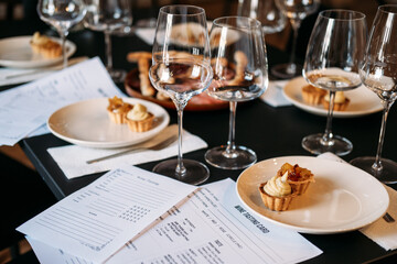 Wine workshop table set with tasting cards, desserts, and multiple glasses prepared for sensory exploration. Wine workshop, hands-on wine education, sensory analysis, sommelier training