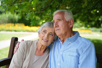 Elderly caucasian couple in park embracing under tree