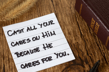 Inspirational handwritten quote for God's love, care and protection with holy bible book on wooden...