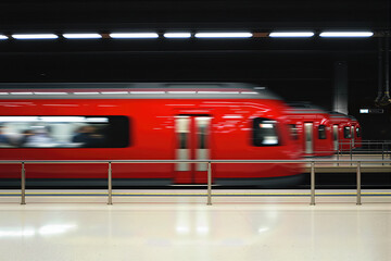 Obraz premium vibrant red train speeding through a modern station