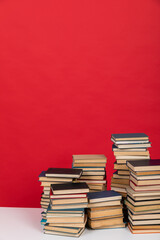Stacks of books on the red background of the university library