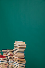 Stacks of old educational books for study in the library on a green background at the university