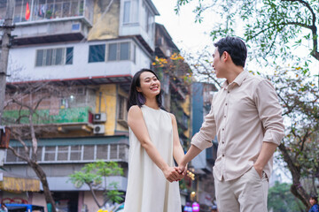 Couple smiling and holding hands in a city street during twilight in an urban setting