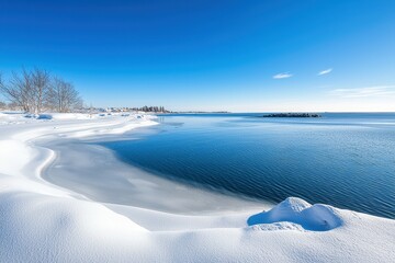 Fototapeta premium Beautiful winter landscape with snowy shores and calm blue waters.