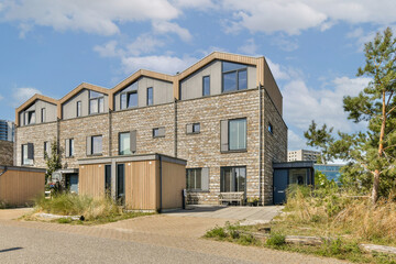 Fototapeta premium This image showcases a contemporary residential building featuring distinct geometric designs and a combination of materials in a well-maintained environment.