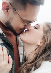 Young couple in stylish clothes on a walk. Romantic date outdoors. Walk, kisses and hugs