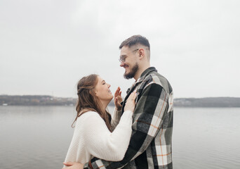 Obraz premium Young couple in stylish clothes on a walk. Romantic date outdoors. Walk, kisses and hugs