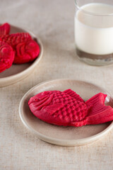 Sweet bread bungeoppang in the shape of a crucian carp fish with banana milk on a table. Poonoppan dessert. Korean food.