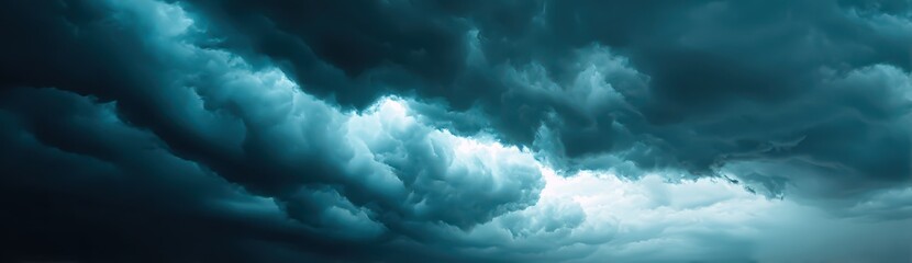 Fototapeta premium Dark clouds swirl dramatically across the sky, indicating an impending storm. The atmosphere is tense, as the sun struggles to break through, creating a moody ambiance over the landscape