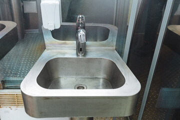 This setup includes a beautifully designed stainless steel sink that is complemented by a convenient soap dispenser positioned right next to it for easy access and functionality