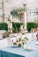 Bouquet of flowers on a festive table next to candles and plates