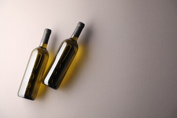 Bottles of wine on light grey background, flat lay. Space for text