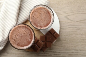 Tasty chocolate milk and bars on wooden table, top view
