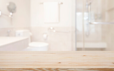Blurred bathroom interior background with wooden texture table top in front
