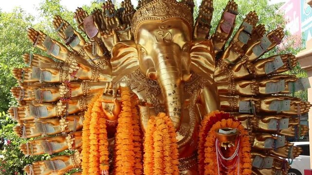 A majestic golden statue of a multi-armed elephant deity stands at Wat Saman Rattanaram in Chachoengsao, Thailand.