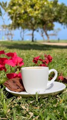 Coffee steam rises from elegant cup, surrounded by vibrant blooms, morning sunlight enhances peaceful coffee moment, nature embraces comforting cup atmosphere.