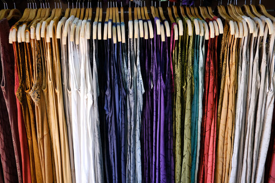 Full frame close-up of a row of Multi-coloured dresses hanging in a wardrobe