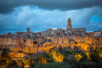 Naklejka premium Pitigliano, Ancient Italian town perched on glowing cliffs at dusk