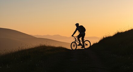 Obraz premium Silhouette of mountain biker enjoying golden hour sunrise ride